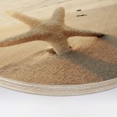 Holzbild Funkelnder Seestern am einsamen Strand - Rund 